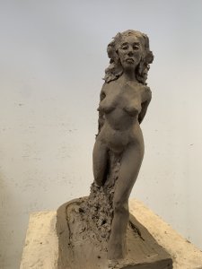 Sculpture en argile représentant une femme nue de face.